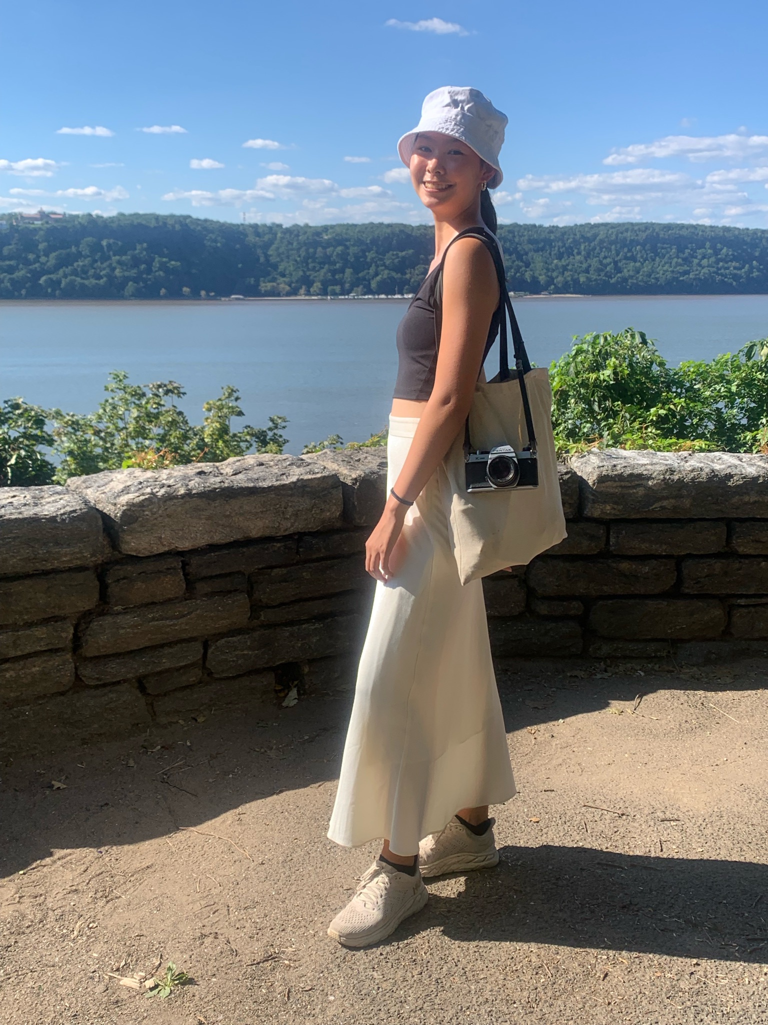 Photo of zine assistant grace on a hill overlooking the hudson river