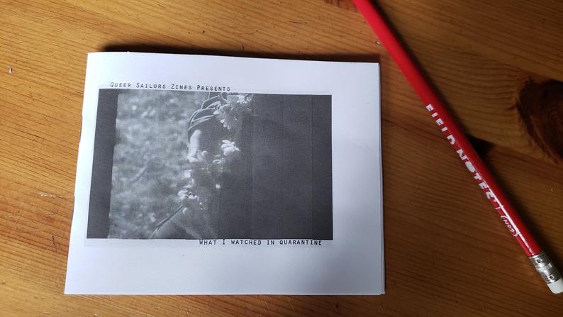photo of zine: What I Watched in Quarantine. Screenshot of computer screen with hand and flowers? 