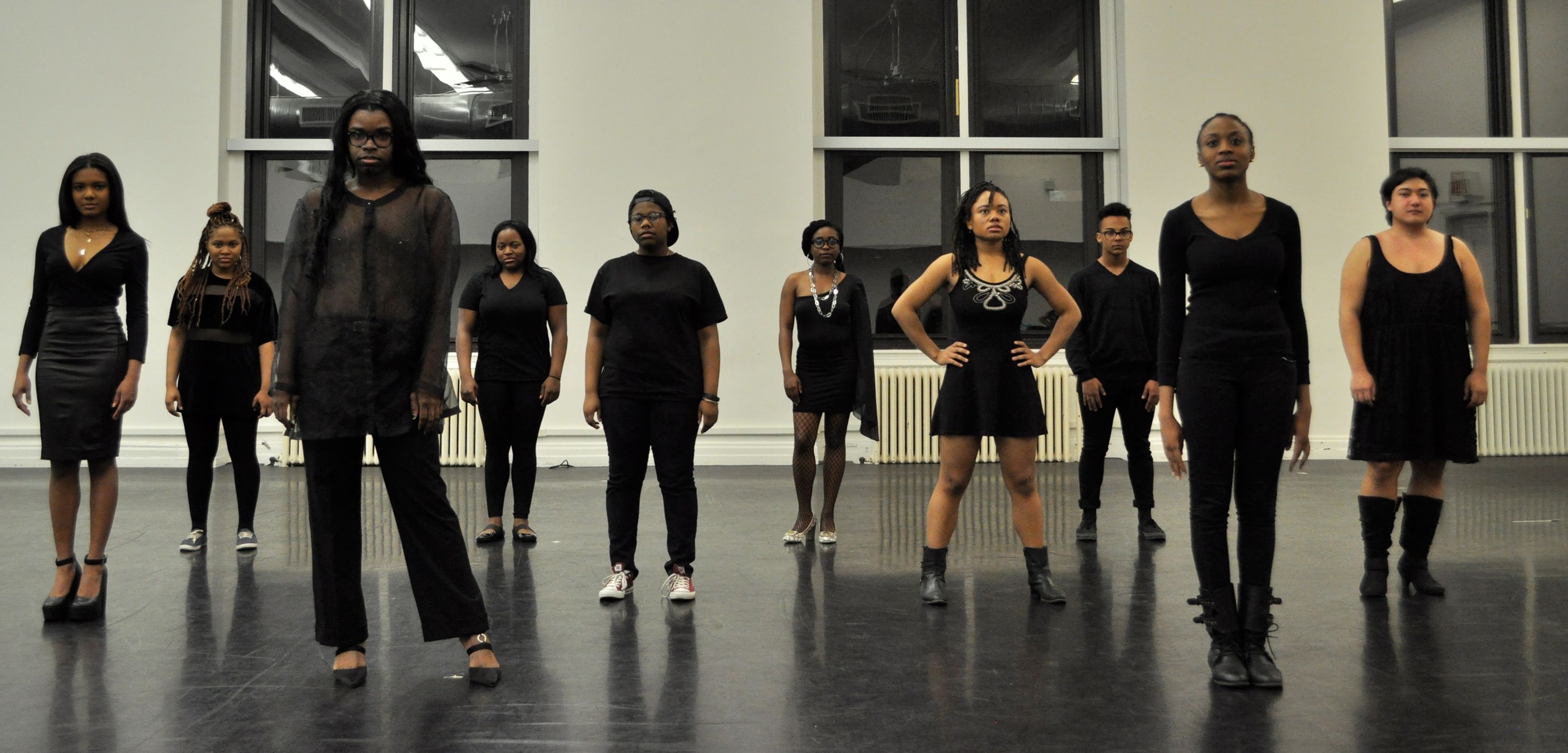 Solange-inspired photo of LGBTQ BIPOC wearing black, standing in a dance studio in three lines