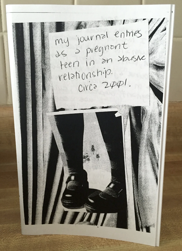 photo of a zine cover: title handwritten on sticky note, calves in tights and feet in chunky shoes below the sticky note