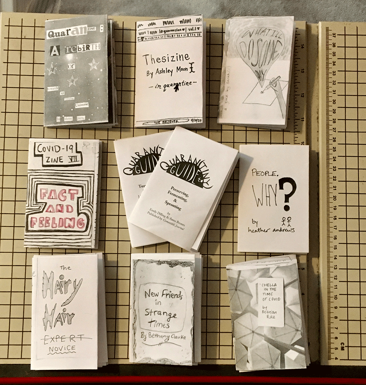 photo of ten one-page folding zines on a paper cutter